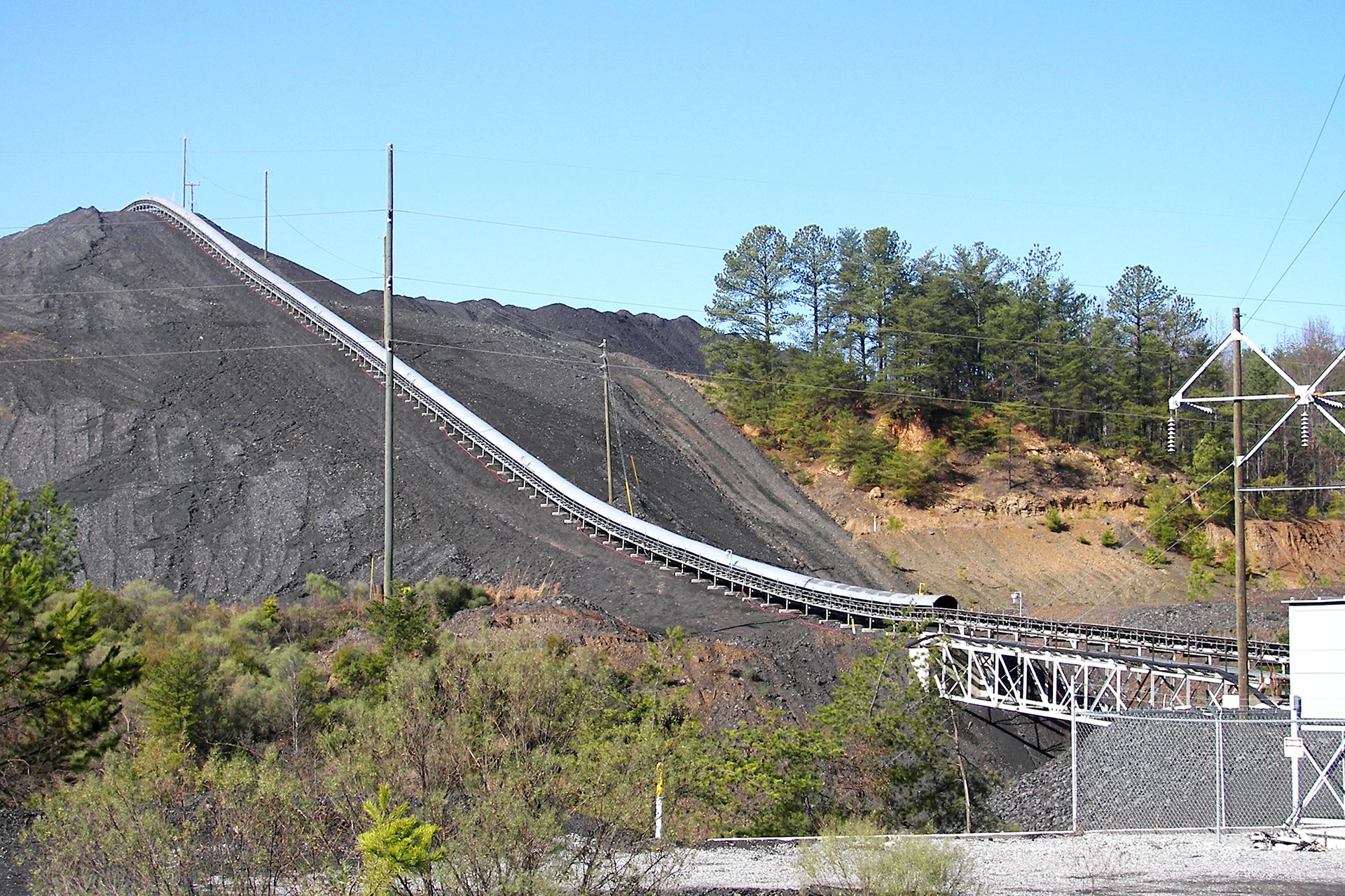 https://dovermg.com/wp-content/uploads/2020/09/Warrior-Met-Coal-Mine-Conveyor-With-Coal-Pile-Web.jpg